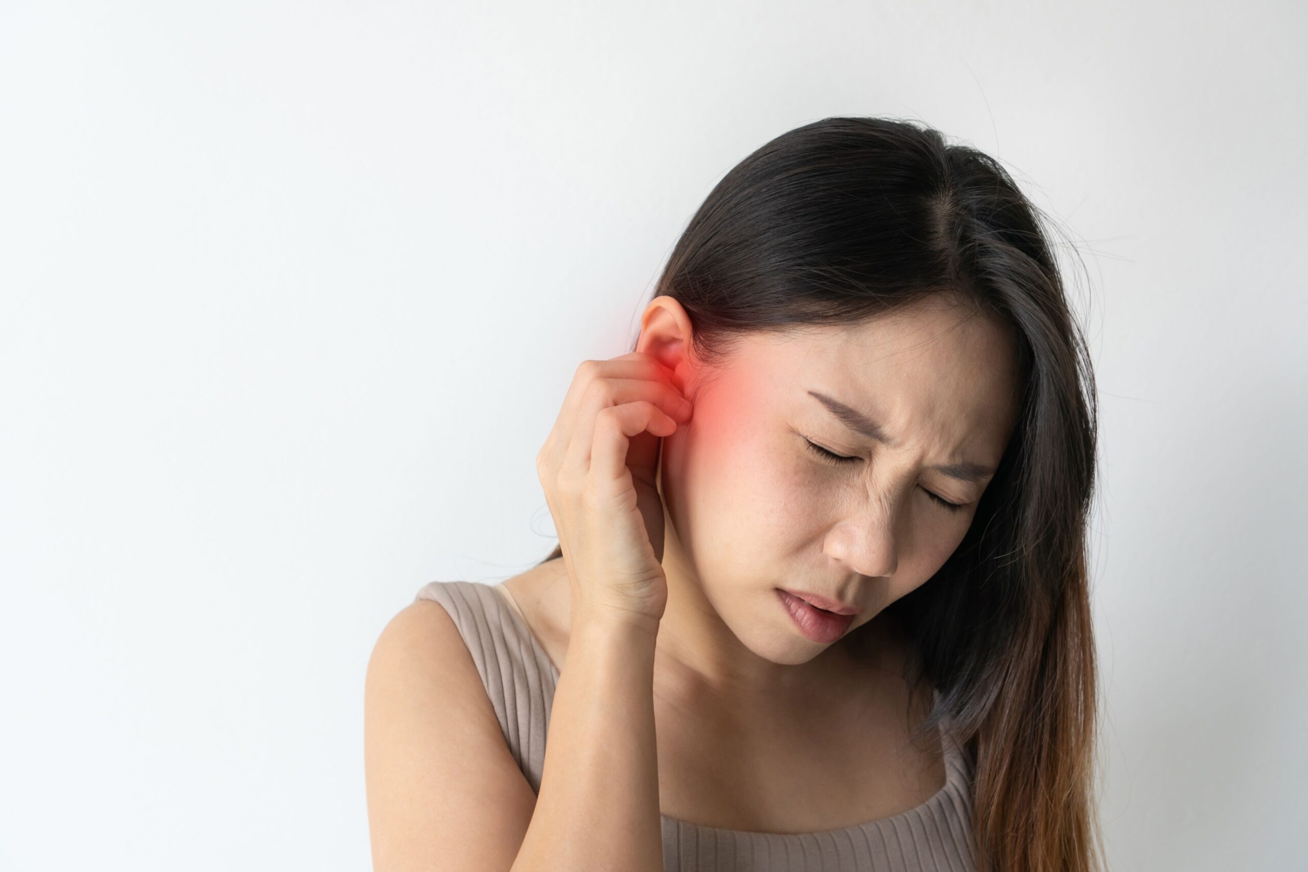 Asian woman holding her ear in pain