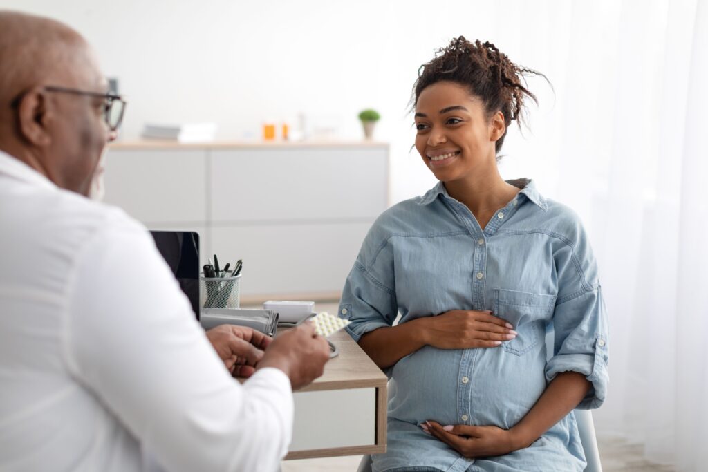 Doctor prescribing prenatal vitamins to pregnant woman